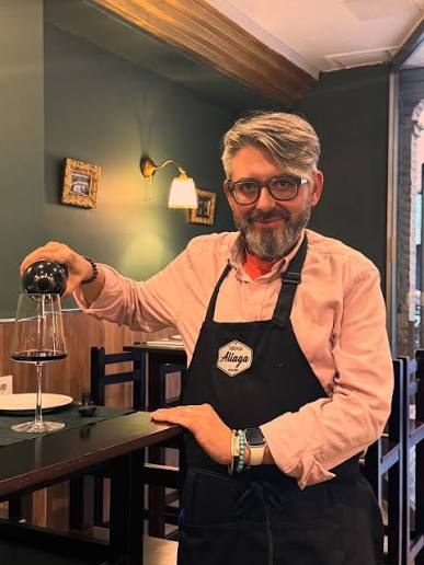 Raúl Aliaga, gerente de Taberna Aliaga, sirviendo una copa de vino en el comedor